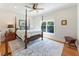 Cozy bedroom featuring a four poster bed, wood floors, and ample natural light from a window at 445 Roper Rd, Canton, GA 30115