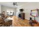 This large bonus room has hardwood floors, a ceiling fan, a TV, and a table set for games at 445 Roper Rd, Canton, GA 30115