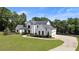 Stunning home exterior with manicured lawn, a circular driveway, and mature trees at 445 Roper Rd, Canton, GA 30115