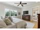 Hardwood floors and a TV mounted on the wall are featured in this main bedroom overlooking the outdoors at 445 Roper Rd, Canton, GA 30115