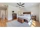 This main bedroom has hardwood floors, a ceiling fan, and a wooden chest at the foot of the bed at 445 Roper Rd, Canton, GA 30115