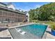 Beautiful backyard pool with built-in loungers, surrounded by a stone patio and lush greenery at 445 Roper Rd, Canton, GA 30115