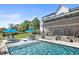 Stunning backyard pool area featuring a screened porch, stylish lounge chairs, and lush landscaping at 445 Roper Rd, Canton, GA 30115