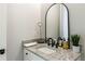 Chic powder room with granite countertop, vessel sink, and arched mirror, adding elegance to the space at 445 Roper Rd, Canton, GA 30115
