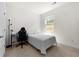 Bright bedroom features neutral walls, carpet, and desk with natural light from window at 1961 Vidalia Ct, Dacula, GA 30019