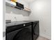 Laundry room featuring stainless steel appliances, a storage shelf, and light gray vinyl flooring at 1961 Vidalia Ct, Dacula, GA 30019