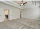 Spacious bedroom featuring a tray ceiling with fan and a bathroom entrance at 3900 Ivy Cottage Dr, Snellville, GA 30039