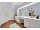 Bright bathroom with double sinks, white cabinets, and hardwood floors at 7545 Brookwood Way, Cumming, GA 30041