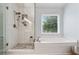 Modern bathroom features a glass enclosed shower and soaking tub with a window view at 7545 Brookwood Way, Cumming, GA 30041
