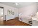 Bedroom showcasing hardwood floors, white furnishings, and soft pink walls at 7545 Brookwood Way, Cumming, GA 30041