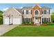 Charming two-story home with a well-manicured lawn, two-car garage, and a classic brick facade at 7545 Brookwood Way, Cumming, GA 30041