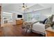 Bedroom featuring tray ceilings, hardwood floors, and an attached bathroom at 7545 Brookwood Way, Cumming, GA 30041