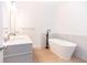 Modern bathroom with a soaking tub and a gray double sink vanity at 27 Hazel St, Porterdale, GA 30014