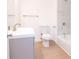 Modern bathroom featuring a single sink vanity, a bathtub with marble surround, and wood flooring at 27 Hazel St, Porterdale, GA 30014