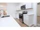 Modern kitchen with white cabinets, stainless steel appliances, and quartz countertops at 27 Hazel St, Porterdale, GA 30014