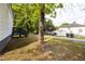 Sideyard of home with a mature shade tree near deck stairs, featuring a lovely landscaped lawn at 27 Hazel St, Porterdale, GA 30014