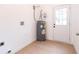 Utility room with modern water heater and neutral flooring near the back door at 27 Hazel St, Porterdale, GA 30014