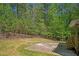 Expansive backyard features a lush lawn, concrete patio, and a rustic wood fence bordering a serene wooded area at 552 Steels Bridge Rd, Canton, GA 30114