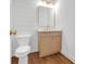 Neutral powder room features a wood vanity and plank wall at 552 Steels Bridge Rd, Canton, GA 30114