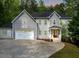 Charming two-story home with a gray exterior, white trim, a two-car garage, and well-manicured landscaping at 552 Steels Bridge Rd, Canton, GA 30114