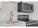 Close-up of a kitchen featuring stainless steel appliances, gold fixtures, and marble countertops at 552 Steels Bridge Rd, Canton, GA 30114