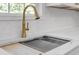 Close up of a modern kitchen sink with a gold faucet and a marble countertop at 552 Steels Bridge Rd, Canton, GA 30114