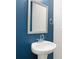 Bathroom featuring a stylish pedestal sink with a chrome faucet and a striking blue wall at 6775 Pippin Walk, Alpharetta, GA 30005