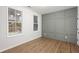 Bright bedroom with two windows, stylish paneled wall, and beautiful hardwood flooring at 6775 Pippin Walk, Alpharetta, GA 30005