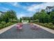 Inviting community space featuring charming pink bistro sets and lush landscaping under a bright, cloudy sky at 6775 Pippin Walk, Alpharetta, GA 30005