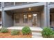 Charming brick entryway with covered porch and natural landscaping leads to a bright, open stairwell at 6775 Pippin Walk, Alpharetta, GA 30005