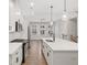 Modern kitchen with white cabinets, stainless steel appliances, a large center island, and elegant pendant lighting at 6775 Pippin Walk, Alpharetta, GA 30005