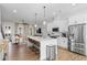 Bright, open-concept kitchen with white cabinetry, stainless steel appliances, and a large center island with seating at 6775 Pippin Walk, Alpharetta, GA 30005