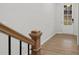 View from the staircase landing with hardwood floors and a partial view of the front door at 6775 Pippin Walk, Alpharetta, GA 30005