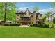 Back exterior of the home with a sprawling green lawn and layered landscaping at 2551 Raintree Ne Dr, Atlanta, GA 30345