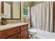 Bathroom featuring granite countertop, wood cabinets, and shower with curtain and window at 2551 Raintree Ne Dr, Atlanta, GA 30345