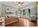 Bedroom with hardwood floors, sitting area by window, decorative art, and a ceiling fan at 2551 Raintree Ne Dr, Atlanta, GA 30345