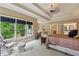 Open main bedroom with tray ceilings, large windows, and sitting area with rocking chair at 2551 Raintree Ne Dr, Atlanta, GA 30345