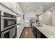 Spacious kitchen boasts white cabinets, stainless steel appliances, and a large island with granite countertops at 4020 Declaration Dr, Roswell, GA 30076
