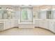 Elegant bathroom with double vanities, soaking tub, and decorative window at 4746 Chamblee Dunwoody Rd, Atlanta, GA 30338