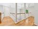 Hallway with hardwood floors, white banisters, and decorative lighting at 4746 Chamblee Dunwoody Rd, Atlanta, GA 30338