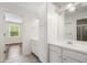 Bright bathroom with white cabinets, double sinks, and a view into an adjacent bedroom at 10192 Shallowford Rd, Roswell, GA 30075