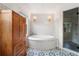 Spa-like bathroom with a soaking tub, separate shower, and a decorative floor at 10192 Shallowford Rd, Roswell, GA 30075