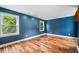 A spacious bedroom with hardwood floors, fresh paint, and natural light from two windows at 10192 Shallowford Rd, Roswell, GA 30075