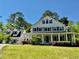 Beautiful white two-story home with black shutters and a welcoming porch in a lush green lawn setting at 10192 Shallowford Rd, Roswell, GA 30075