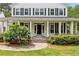 Charming two-story home featuring a covered front porch, white siding, black shutters and nicely manicured landscaping at 10192 Shallowford Rd, Roswell, GA 30075