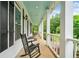 Relax on this covered porch with rocking chairs and a cool blue ceiling perfect for enjoying the outdoors at 10192 Shallowford Rd, Roswell, GA 30075