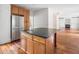 Kitchen island features sink and beautiful granite counter with view to living room and fireplace at 10192 Shallowford Rd, Roswell, GA 30075
