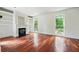 Inviting living room with a fireplace, built-in shelves, hardwood floors, and natural light from large windows at 10192 Shallowford Rd, Roswell, GA 30075