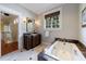 Elegant bathroom with a soaking tub with marble surround, vanity, and detailed window at 3 Demorest Ne Ave, Atlanta, GA 30305