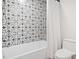 Bathroom featuring a patterned tile accent wall and white fixtures at 369 Arnold Mill Rd, Woodstock, GA 30188